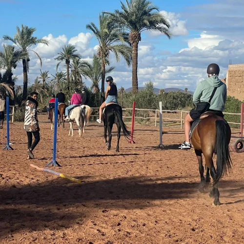 Débutant accompagné pendant une balade à cheval dans la Palmeraie